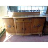 An early 20th century continental oak shaped front four door sideboard with carved rail back