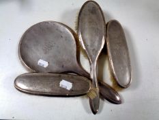 A four piece Birmingham silver backed dressing table brush and hand mirror set dated 1924