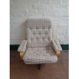 A late 20th century swivel armchair upholstered in a cream checked fabric on chrome base