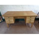 A blonde oak twin pedestal desk fitted six drawers