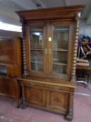 A 19th century oak double door bookcase with bobbin column supports,