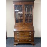 An early 19th century mahogany bureau bookcase on bracket feet