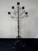 A wrought iron floor standing five way candle stand