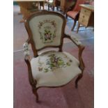 A carved beech framed French salon armchair upholstered in a tapestry fabric