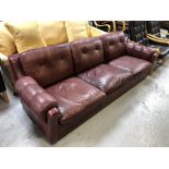 A twentieth century Continental three seater settee in Burgundy leather upholstery