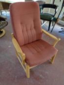 A wood framed armchair upholstered in a pink fabric
