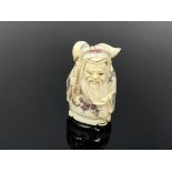 A carved Chinese netsuke - Bearded man with sack on his back