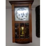 An Edwardian wall clock with silvered dial