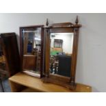 An oak framed bevel edged hall mirror with shelf and finials together with a further mahogany
