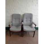 A pair of stained beech high backed armchairs upholstered in a grey fabric