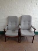 A pair of stained beech high backed armchairs upholstered in a grey fabric