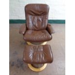 A brown leather swivel adjustable armchair with stool