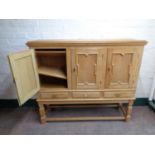 A continental blonde oak triple door sideboard fitted three drawers on raised legs
