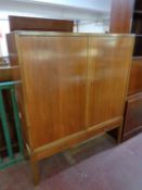 A mid 20th century teak double door sideboard fitted two drawers beneath on raised legs