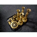 A tray of assorted brass ware to include antique brass candlestick, door handles, horse brasses,