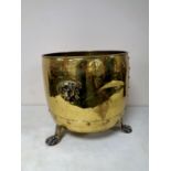 A 19th century brass log bucket with lion mask handles on claw and ball feet