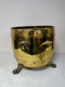 A 19th century brass log bucket with lion mask handles on claw and ball feet