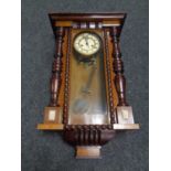 An Edwardian eight day wall clock with pendulum and key