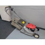 A Honda self drive petrol lawn mower with grass box