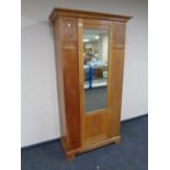 An Edwardian oak mirror door wardrobe