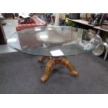 A contemporary circular glass topped dining table on four way pedestal