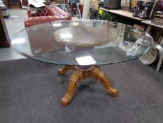 A contemporary circular glass topped dining table on four way pedestal