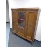 A 20th century continental triple door sideboard with glazed central door