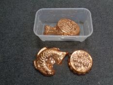 A box containing four copper jelly moulds