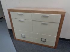 A pine effect high gloss fronted eight drawer chest