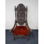 A 19th century heavily carved oak throne armchair