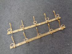 A pair of cast iron wall mounted five peg coat hangers