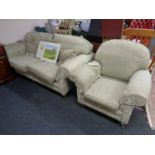 A two seater settee and matching armchair upholstered in a green and gold classical floral print