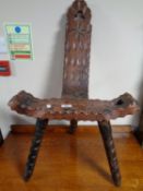 A carved beech tripod chair