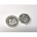 Two Elizabeth II silver proof coins comprising a 2020 £5 coin and a 2011 $1 coins commemorating the
