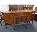 A Regency style shaped front inlaid mahogany sideboard on raised legs