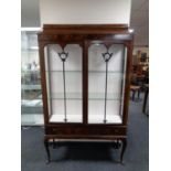 A late 19th century mahogany double door glazed display cabinet fitted two drawers beneath on