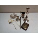 A box containing silver items to include cigarette case, sugar tongs, silver handled button hook,