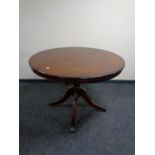 A Regency style circular inlaid dining table fitted a leaf on pedestal