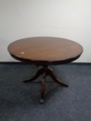 A Regency style circular inlaid dining table fitted a leaf on pedestal