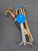 Two bundles of assorted walking sticks and umbrellas to include walking cane with silver pommel