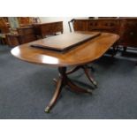 A Regency style twin pedestal extending dining table with two leaves