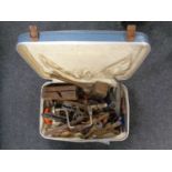 A suitcase containing a quantity of vintage hand working tools to include brace, planes, mallet,