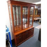 A Morris Furniture triple door bookcase fitted cupboards and drawers beneath