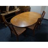 A 20th century oval teak G Plan extending dining table together with a set of five rail back chairs