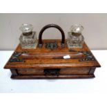An Edwardian oak desk stand fitted a drawer with two cut glass inkwells
