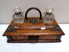 An Edwardian oak desk stand fitted a drawer with two cut glass inkwells