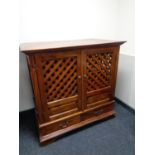 A hardwood double door television cabinet with lattice doors fitted two drawers beneath