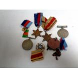 A tin containing World War II medals to include the War and Defence medal, the African Star,