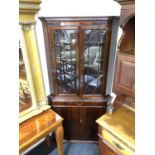 A mahogany double door corner display cabinet fitted cupboard and drawer beneath