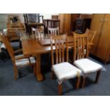 A contemporary oak refectory pull out dining table with leaf together with a set of six Arts &